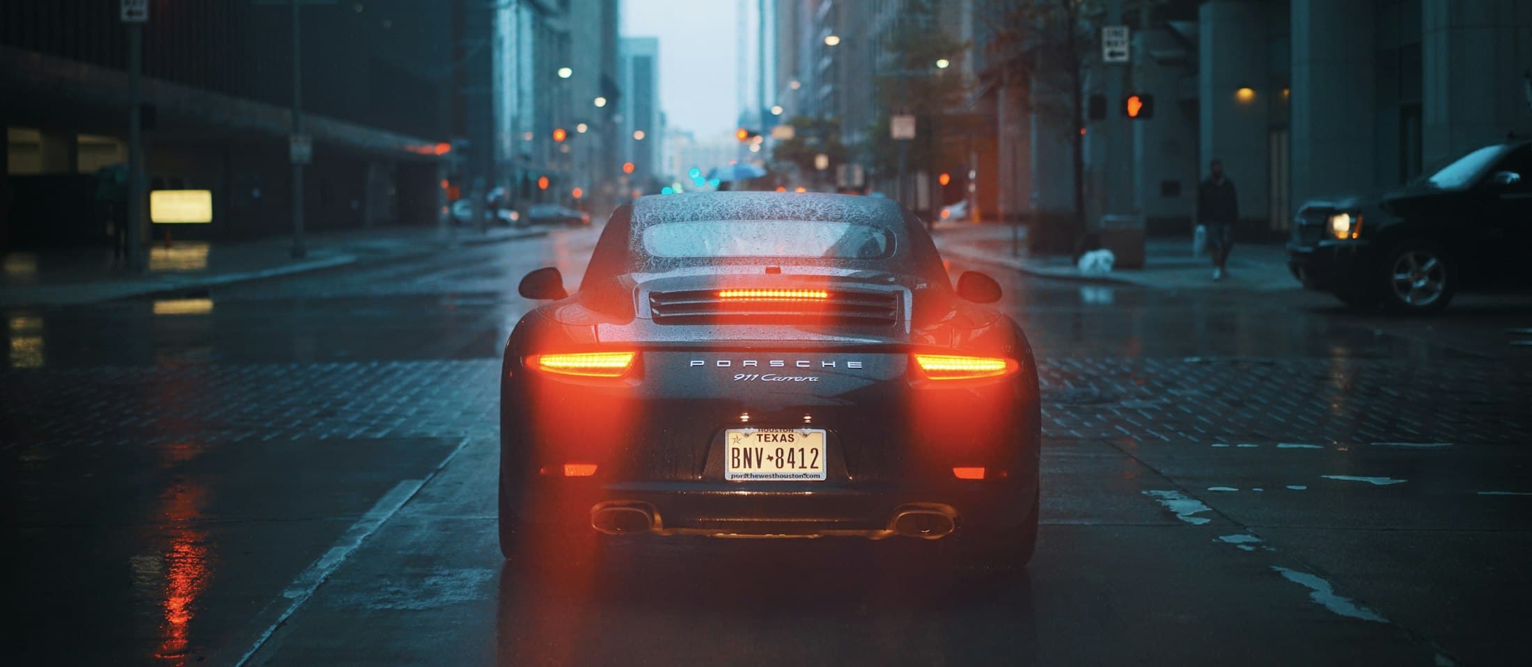Feux arrière d'une Porsche 911 dans une rue de nuit