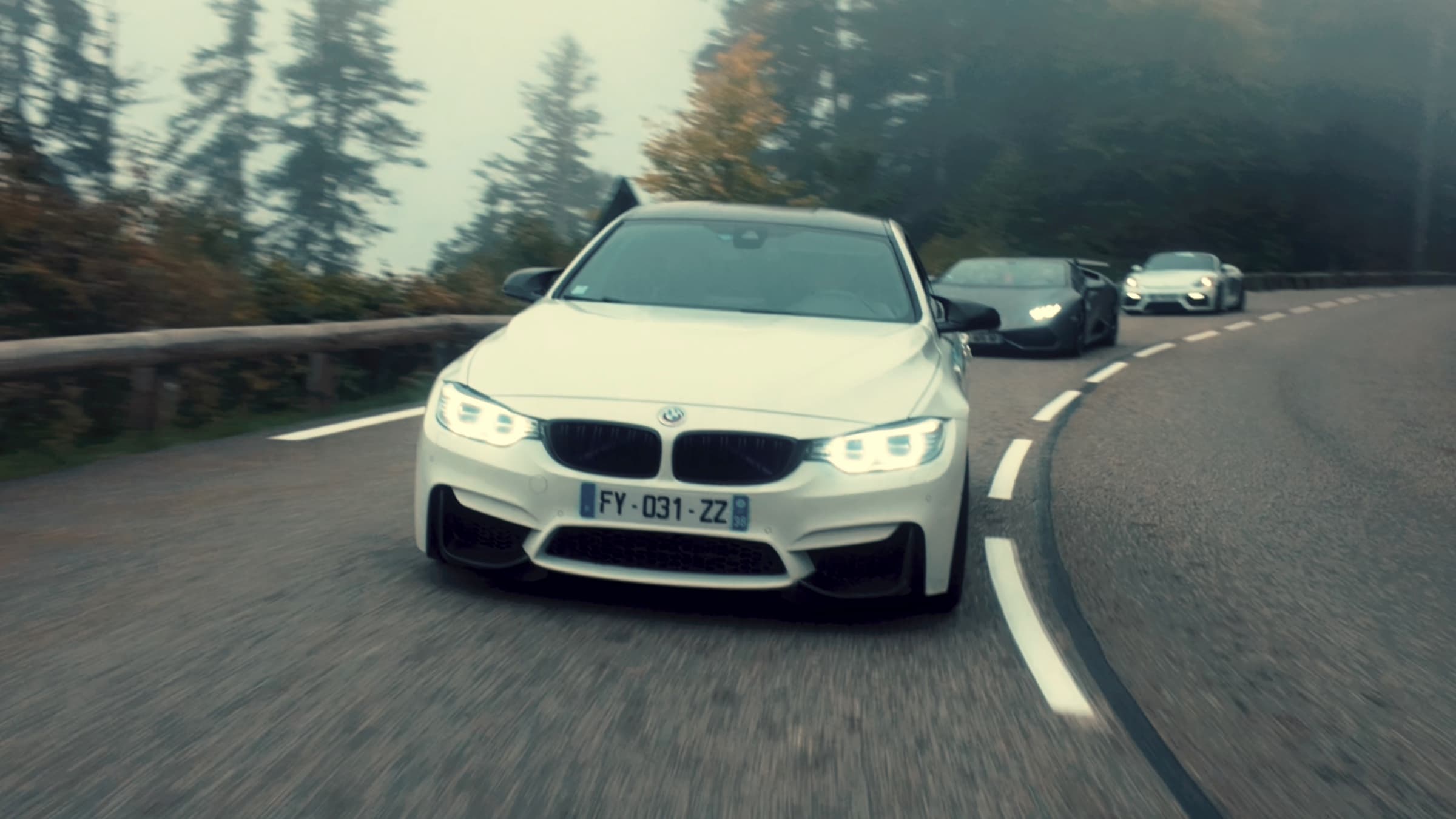 BMW M4 blanche dans un virage en forêt