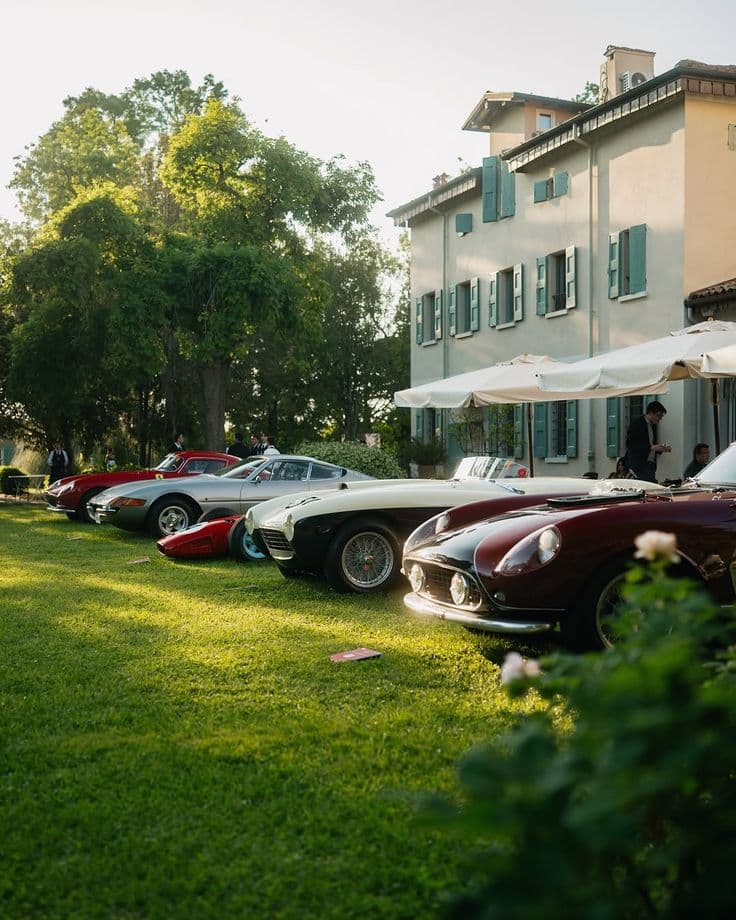 Voitures de collection alignées sur la pelouse d'une villa